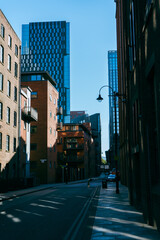 Fototapeta premium Buildings in Manchester city centre with blue sky brickwork backstreets 