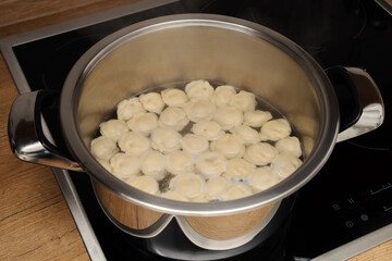Pan on the stove with meat dumplings boiled in water.