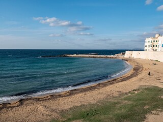 Waterfront and sandy beach at sunny Gallipoli, Italy and Seno della Purita bay at sunset