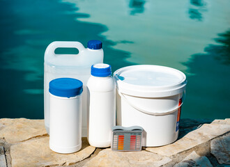 Obraz premium High angle view of equipment for testing the quality of pool water and chemical cleaning products at the edge of swimming pool