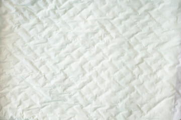 closeup white and soft baby cloth crumpled diapers or disposable flat bed sheet with square background and texture