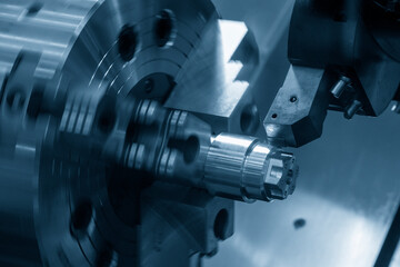 Obraz na płótnie Canvas The CNC lathe machine forming cutting the metal shaft parts.