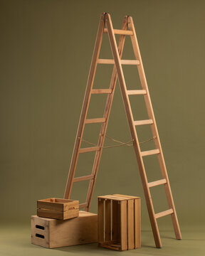 Wooden ladder and wooden box on khaki background