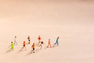 Foto op Plexiglas Miniature People exercising while running in a group on the beach. Living an active lifestyle concept © Sirichai Puangsuwan