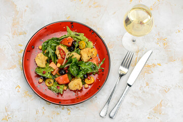 fresh salad with chicken and tomatoes in a red plate
