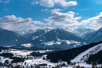 Beautiful aerial panorama view of Ramsau am Dachstein village and Schladming with Planai and other peaks of Alps in background with blue sky cloud in winter, Austria - 523209577
