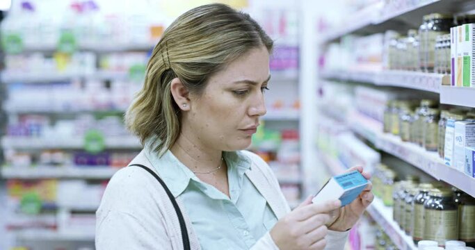 Pharmacy customer and healthy woman choosing medicine for treatment on a shelf in a drugstore. A woman thinking while browsing healthcare and wellness products in an aisle in a pharma retail store