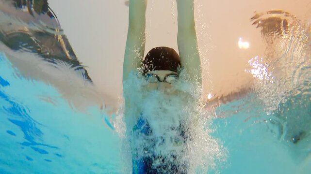 Sports woman swims underwater during a competition. Slow motion sports shooting underwater.