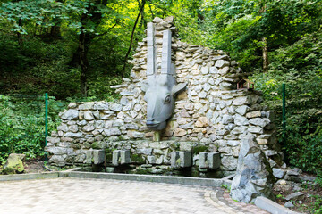 Sculpture head of a ram in the park.