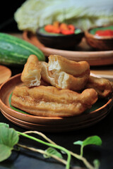 This is Cakwe or Fried Bread, Traditional Chinese Snacks with a long oval shape. With cucumber, chili sauce, white cabbage as a complement