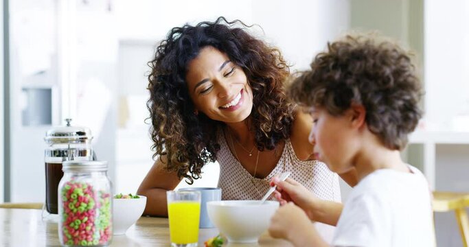 Happy, Proud And Loving Mother Watching Her Son Eat Breakfast In The Kitchen While Bonding Together As A Family. Young Woman Smiling And Talking To Her Cute Little Boy Child In The Morning At Home