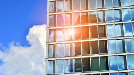  Modern glass facade against blue sky. Bottom view of a  building in the business district. Low angle view of the glass facade of an office building.