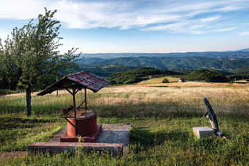 Old water well pump in rural mountain gardenscenery