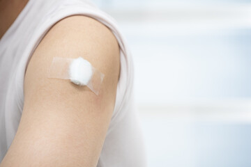A man with medical plaster on arm after get covid 19 vaccine