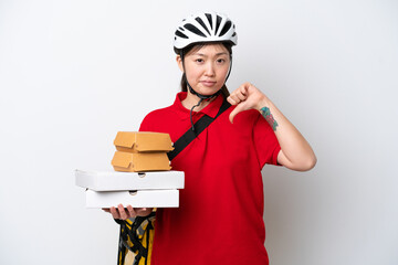 Young Chinese delivery woman taking takeaway food isolated on white background showing thumb down...