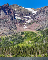 Summer snow fields on Rising Wolf Mountain rising above Two Medicine Lake, Glacier National Park,...