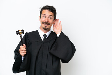 Naklejka premium Young judge caucasian man isolated on white background listening to something by putting hand on the ear
