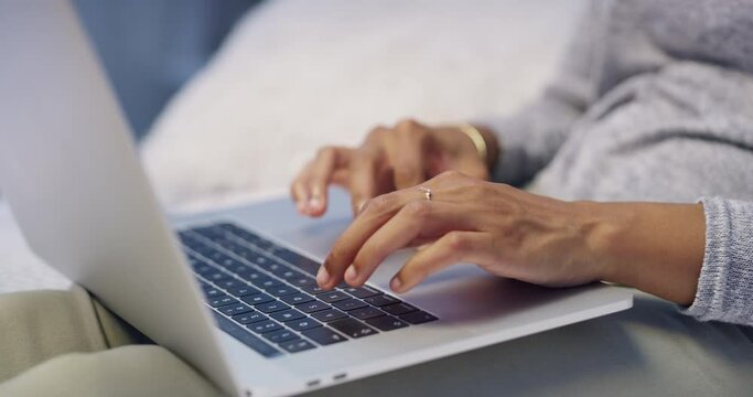 Hands typing on laptop, browsing the internet or searching online while relaxing on bed in home bedroom. Closeup of relaxed, lounging or comfortable woman or blogger preparing blog post on technology