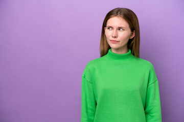 Obraz premium Young English woman isolated on purple background having doubts while looking side