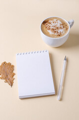 Empty white notepad with a cup of coffee on a light background