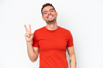 Young caucasian handsome man isolated on white background smiling and showing victory sign