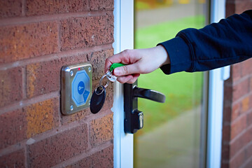 White womans hand using magnetic key fob to gain access to shared accommodation from outdoors
