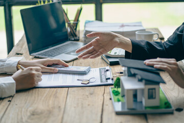 Home agents talk to new home buyers and offer good interest rates and calculate clients on mortgage...