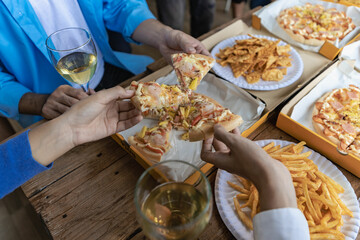 Group of male and female colleagues having pizza lunch together at the office after work celebration concept
