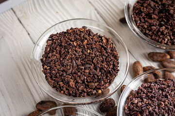 Cacao nibs with cacao beans on old wooden background