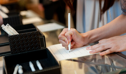 受付で署名をする女性の手元　冠婚葬祭