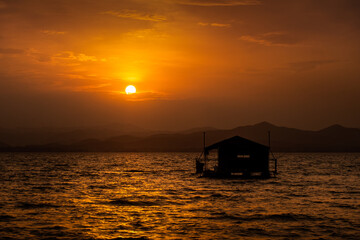 Sunset, beautiful scenery, mountains in dams, large reservoirs and floating rafts. © sittitap