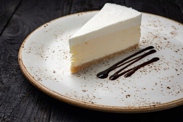 piece of cheesecake with cream and chocolate on a white plate