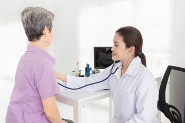 Obraz premium close up doctor, Asian doctor talk with old female patient about disease symptom, doctor use stethoscope listening to chest of patient, elderly health check up, happiness hospital