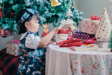 Asian baby in Christmas party celebration festival. Cute 1 year happy baby doing activity, smiling at home with family as Christmas concept.