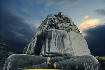 Obraz premium Big Buddha carved in stone on the cliff.