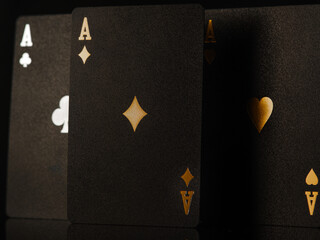 Black stylish poker cards with gold embossing, three aces. Close-up. Casino, online casino. Risk, luck, winning, gambling. There are no people in the photo. Advertising, banner.