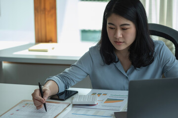 Business woman holding pen to present profit data in graph to supervisor via laptop computer.