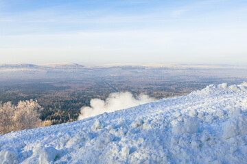 snow on the slope of the ski resort, the background is a forest winter landscape