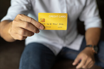 businessman show credit card, man sitting on sofa Living room at home.