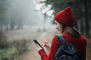 Travel Apps. Young woman traveler with backpack holding smartphone device in hands