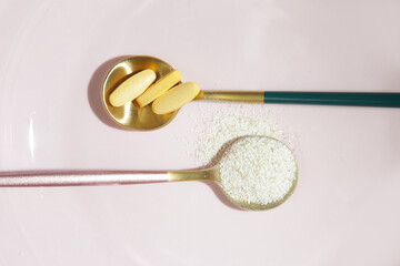 Collagen powder and pills in spoon. Concept of nutritional supplement for skin beauty	