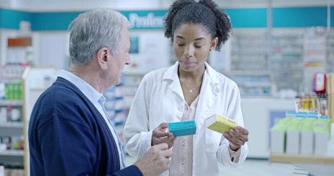 Friendly, helpful and experienced pharmacist assisting a senior customer with medication on a shelf in a pharmacy. African healthcare worker explaining dosage instructions to an elderly man