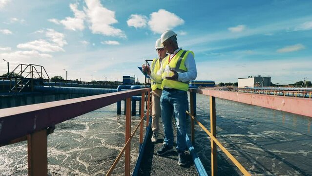 Wastewater operators examining water samples at a wastewater cleaning facility