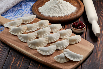 raw dumpling with cherries on the wooden board