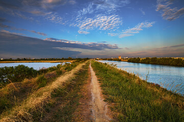 Comacchio, Emilia Romagna, Ferrara, Italy: landscape at sunset of the swamp with the path that...