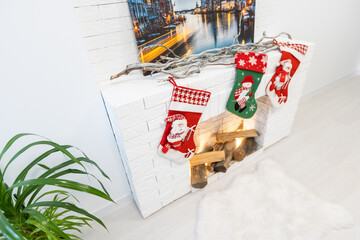 Fireplace with Christmas stockings in festive room interior.