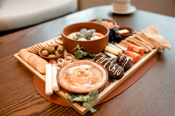 Traditional arabic breakfast on a table: eggs with tomatoes,  green olives, hummus, pitta bread, cucumbers, falafel, honey and butter, cheese
