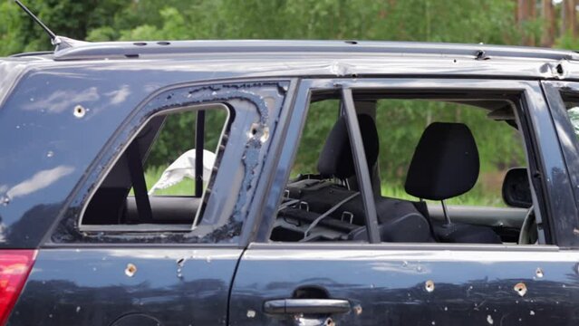 Car riddled with bullets. War of Russia against Ukraine. Shot car of civilians while trying to evacuate from the combat zone in the Kyiv region. Traces of bullets in the back of a car.