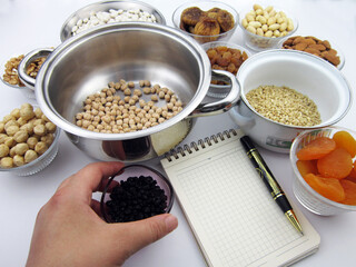       Traditional Turkish dessert ashura ingredients.A hand holding currants                        