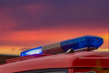Blue emergency lights off on red fire truck against a purple-red stormy sky. Light of fire engines. Emergency vehicle lighting
